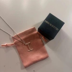 Maria Nilsdotter halsband  - Snyggt halsband i äkta silver från Maria Nilsdotter med ett coolt I-format hänge. Kedjan är tunn och stilren, perfekt för dig som gillar minimalistisk design. Levereras med original ask. Märkt 925 på hänget för äkta silver. Nypris är 1900kr