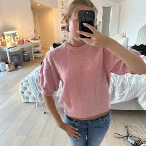Rosa stickad tröja  - Supersöt rosa stickad tröja från Gina Tricot i storlek S med puffiga halvlånga ärmar och croppad passform. Mjuk och skön, med ribbad hals och nederkant. Använts fåtal gånger och är i fint skick med inga defekter. 
