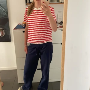 Rödvit randig t-shirt från H&M - Randig t-shirt från H&M i storlek S. T-shirten har röda och vita horisontella ränder, klassisk rund hals och korta ärmar. Skön och lätt i bomull, perfekt till jeans eller shorts för en chill look.