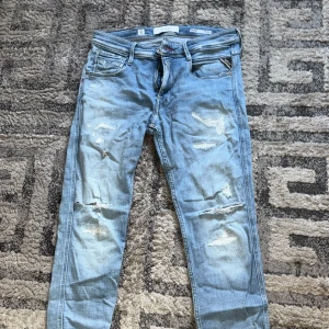 Replay Bronny ljusblå slitna jeans - Ljusblå jeans från Replay, modell Bronny Super Slim Fit. Byxorna har skinny passform, slitna detaljer och klassisk femficksdesign. Perfekta för dig som gillar en smal siluett och en trendig, avslappnad look. Skick 6/10 w30 l32 ny pris 2000 mitt pris 200