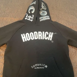 Svart hoodie från Hoodrich med tryck - Svart hoodie från Hoodrich i storlek M med stora vita tryck både fram och bak samt på huvan. Klassisk känguruficka framtill och coola detaljer med texten 'From Nothing To Something'. Perfekt för dig som gillar streetwear och vill sticka ut.