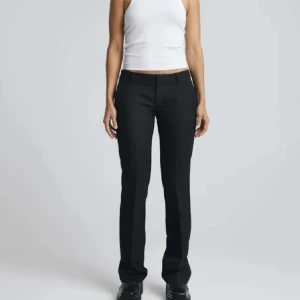 svarta låg midjade kostymbyxor  - Snygga svarta kostymbyxor med bootcut nertill och lågmidjade. Modellen heter Vera på BikBok, ny pris 499