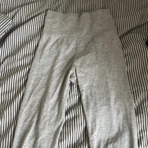 Grå yoga pants från Nelly XXS - Snygga ljusgrå yoga pants  från Nelly i storlek XXS. De har hög midja och är gjorda i ett mjukt och stretchigt material som sitter tight och bekvämt. Perfekta för chill eller träning. Enkel design utan detaljer för en clean look. Ser bra ut med allt.