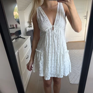 Vit spetsklänning med knyt och v-ringning - Superfin vit kortklänning i spets med djup v-ringning och knyt i ryggen. Denna har endast används ett fåtal gånger så den är i superfint skick!🤍