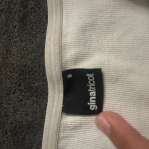 Vit ribbad kortkjol/ topp från Gina Tricot - Supersnygg vit ribbad kortkjol från Gina Tricot i storlek S. Funkar utmärkt att använda som topp, plagget har en enkel och clean design med stretchigt material som sitter tajt och bekvämt. Perfekt att matcha med en crop top eller oversized hoodie för en chill look.