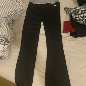 Svarta bootcut byxor med stretch - Svarta bootcut byxor med bred resår i midjan och stretchigt material. Snygg passform som sitter tajt upptill och släpper ut vid benen. Perfekta för en chill och trendig look.