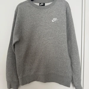 Grå Nike sweatshirt - Klassisk grå sweatshirt från Nike. Perfekt för en chill och sportig stil. Storlek XS men är mer som S/M