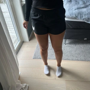 Svarta träningsshorts från Nike - Svarta träningsshorts från Nike med tryck på sidan. 