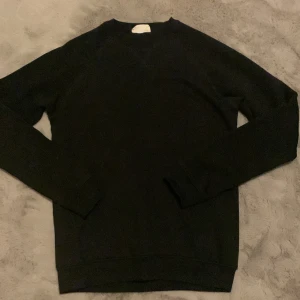 Svart sweatshirt från Pier One - En stilren svart sweatshirt från Pier One med rund halsringning och långa ärmar. Tröjan har en klassisk passform och är tillverkad i mjuk bomull, perfekt för en clean och enkel look. Passar dig som gillar basic och tidlös stil.