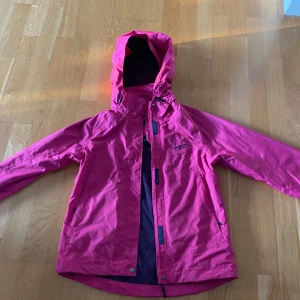 Rosa vindjacka från North Bend - Snygg rosa vindjacka från North Bend med huva och dragkedja framtill. Jackan har praktiska fickor och är perfekt för blåsiga dagar. Lätt och smidig design som funkar till många olika outfits.