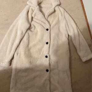 Beige teddyjacka med knappar - Jag säljer en teddykappa för 8999 kr jag köpte den för 9000  kr. Den är i storlek M (38/40). Och passar perfekt till kalla dagar och säsonger håller en varm länge.