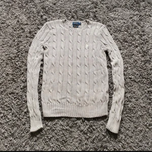 Grå kabelstickad sweater tröja Dam Polo Ralph Lauren - Säljer en klassisk grå kabelstickad tröja från Polo Ralph Lauren i mjuk pima cotton. Inga skavanker. Storlek S, sitter fint o tight. 