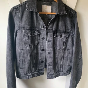 Svart/grå jeansjacka från Pernilla Wahlgren - Säljer en snygg svart/grå jeansjacka från Pernilla Wahlgren i storlek XS men skulle säga att den passar. S mkt bättre. Klassisk modell med knappar framtill, två bröstfickor med lock och två sidofickor. Perfekt att slänga över en t-shirt eller hoodie.