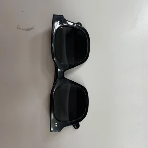 Svarta solglasögon med bred båge - Stilrena svarta CHIMI solglasögon med bred, fyrkantig båge och mörka glas. Klassisk design som passar till många stilar. I storlek 04!😀Hel svarta. Med kommer skydd i både tyg och hårt skal!