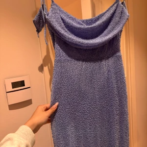 Ljusblå långklänning från oh Polly . Balklänning  - Säljer en ljusblå långklänning från oh Polly med glittriga detaljer och draperad urringning. Klänningen har smala axelband och en figurnära passform, perfekt för speciella tillfällen som till exempel balen . Bara använt den 1 gång!