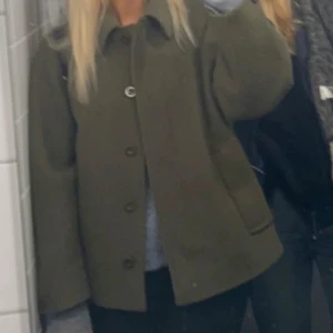 Grön ullkappa från COS - Säljer min gröna korta kappa från COS i ull. Använd en vinter men i mycket bra skick! Den är i storlek S men är lite oversized.💚