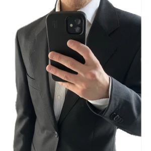 Mörkgrå kostym från Ermenegildo Zegna - Elegant mörkgrå kostym från Ermenegildo Zegna. Kavajen har klassisk design med knappar och byxorna har en stilren passform. Perfekt för formella tillfällen.  Mått kavaj: Längd baktill från slutet av krage och ner: 70cm.  Axel till axel: 44 cm.  Armhåla till armhåla: 42cm.  Ärm 60 cm.  Mått byxa:   Längd: 93 cm. Insida ben: 71 cm. Öppning ben 19 cm. Midja: 40 cm.   (Mått tagna med plagget liggandes platt)