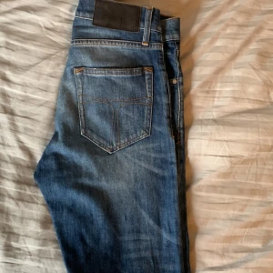 Blå jeansbyxor Pistelero 27/32 - Säljer ett par klassiska blå jeansbyxor från Tiger Of Sweden, Modell ” pistolero ” storlek 27/32. Slim fit i passform. Priset sitter inte i sten, hör av dig vid frågor! :-) 