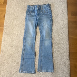 Bootcut jeans i ljusblå denim från H&M - Säljer ett par ljusblåa jättesnygga low waist jeans från HM på grund av att de är för små. Storleken är 146.  Köparen står för frakten🤗Hör av er vid frågor