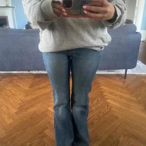 Blå bootcut jeans - Säljer ett par lågmidjade blå bootcut jeans med normal passform. 