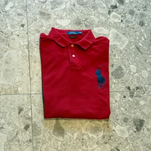 Röd pikétröja från Polo Ralph Lauren - Säljer en klassisk röd pikétröja från Polo Ralph Lauren. Tillverkad i 100% bomull. Nypriset ligger på cirka 1500kr