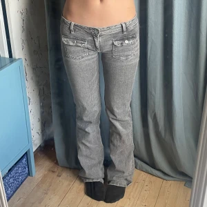 Super lågmidjade bootcut jeans - Säljer ett par grå bootcut jeans. (Har sytt dem mer lågmidjat än de va originellt) . Midjemått: ca 37cm men dem är stretchiga. Innerbenslängd ca 84cm. Dem har lite små defekter längst ner då dem är för långa för mig, kan skicka bild!💕Priset kan diskuteras