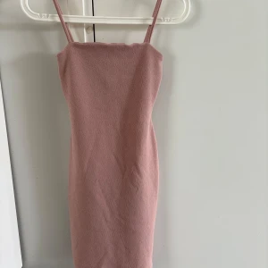 Rosa tight klänning från NLY One - Säljer en ljusrosa tight klänning från NLY One med smala axelband och rak halsringning. Klänningen är kort och har en enkel, stilren design som passar perfekt till sommaren. Se sista bild när jag har den på mig. Hann bara bli använd en gång 