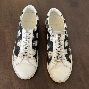Saint Laurent sneakers med mönster - Säljer ett par ovanliga sneakers från Saint Laurent med vitt och svart mönster. Köptes i Barcelona på la roca village. Storlek 41 men passar även storlek 40.