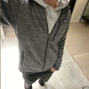 Patagonia jacka - Säljer en grå fleecejacka från Patagonia med dragkedja och hög krage. Jackan har en normal passform och är perfekt för kyligare dagar. Den har praktiska fickor med dragkedjor och en diskret logga på bröstet. Storleken är XS som är 173 priset går att diskutera🤩