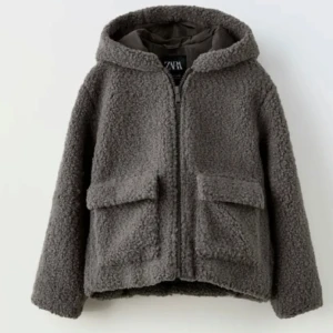 Grå teddyjacka från Zara - Mysig grå teddyjacka från Zara med huva och dragkedja framtill. Jackan har två stora fickor. Skriv för frågor eller fler bilder!🥰