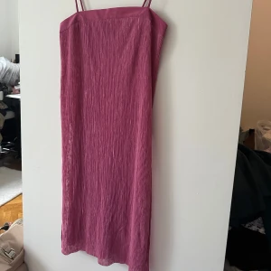 Rosa klänning från Zara - Säljer en snygg rosa klänning från Zara med smala axelband och en slits på sidan. Klänningen har en ribbad textur som ger en cool look. Perfekt för sommarens alla tillfällen! 🌸