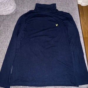 Lyle & Scott tröja i storlek 170/XS - Mörkblå tröja med krage som endast använts en gång, därav i nyskick.  Nypris: 599kr