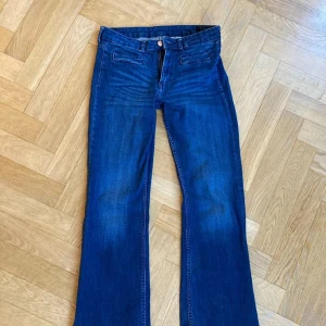 low waist bootcut jeans - Snygga blå bootcut jeans med klassisk design. De har en knapp och dragkedja framtill samt fickor både fram och bak. Perfekta för en avslappnad stil.