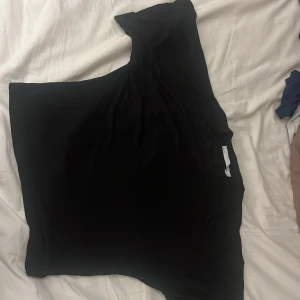 Svart kortärmad topp från 157 - Säljer en stilren svart topp från 157. Den har korta ärmar och en bekväm passform. Perfekt för en enkel och snygg look. Passar bra till både jeans och kjol.