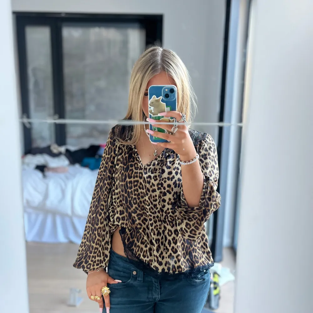 Leopard blus med spets vid halsen. Man kan knytta den eller ha den öppen.. Puserot.