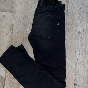 Svarta Replay anbass - Snygga svarta jeans från Replay med en slim passform. De har en klassisk femficksdesign och ett snyggt silvrigt R på bakfickan.😍Perfekta för en stilren look. Storleken är 28/32 och de sitter väldigt bra!😁😁Säljer då de ej kommer till användning. Hör gärna av dig om du har några funderingar!!🤗🤗