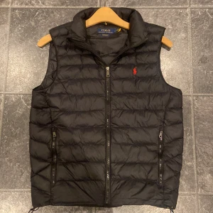 Ralph lauren väst - en ralph lauren väst som är perfekt nu till våren när det blir för varmt för jacka, funkar även till hösten också. den är i väldigt fint skick och inte använd så mycket . kanske någon liten tråd eller skavank som syns men inget som påverkar. västen är självklart äkta