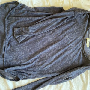 Mörkgrå långärmad tröja - Säljer en mörkgrå långärmad tröja med en avslappnad passform. Tröjan har en rund halsringning och är tillverkad i ett mjukt material som känns skönt mot huden. Perfekt för kyligare dagar.