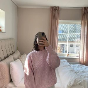 Rosa stickad tröja från H&M - Mysig rosa stickad tröja från H&M. Perfekt för kyliga dagar med sin avslappnade passform och långa ärmar. Tröjan har en ribbad struktur som ger extra stil och komfort. Ett måste i garderoben för en trendig look!