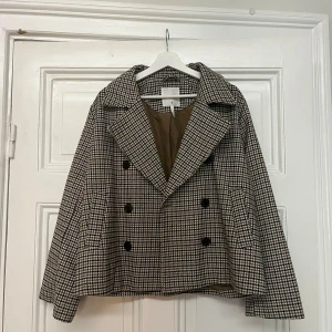 Rutig kort kappa från Object - Säljer en rutig kort kappa från Objekt som är använd fåtal gånger! Superfin nu till våren. I storlek 36, med vida armar och en v ringning!🌞