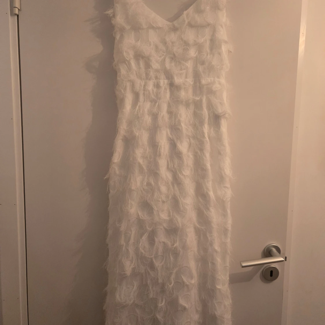 Vit klänning med fjäderdetaljer