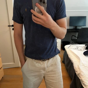 Blå pikétröja från Ralph Lauren - Säljer en stilren marinblå pikétröja från Ralph Lauren i slim fit. Tröjan har klassisk krage, tre knappar framtill och den ikoniska broderade polospelaren på bröstet. Perfekt till sommaren och enkel att matcha med shorts eller jeans. Har bara använt den tre gånger går att få den för 600 vid snabb affär!