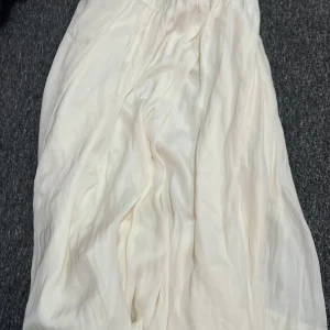 Vit långkjol från Gina Tricot - Luftig och flowy vit långkjol från Gina Tricot i storlek XS. Kjolen har resår i midjan och är tillverkad i ett tunt, mjukt material som ger en snygg siluett. Perfekt för dig som gillar en clean och enkel stil. Köpt för 400 kr och använd endast 2 gånger.