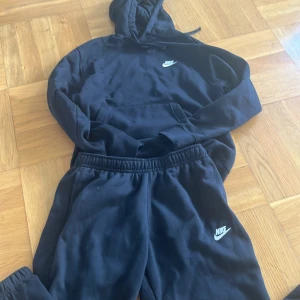 Svarta mjukisbyxor från Nike M - Svarta mjukisbyxor från Nike med klassisk logga broderad i vitt på benet. Byxorna har resår i midjan och är gjorda i mjukt bomullsmaterial för maximal komfort. Perfekta för chill eller träning, loose fit och enkel stil.