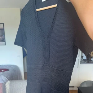 Sandro klänning - Svart klänning från sandro - typ virkad - storlek S i jättefint skick, sitter tight upptill och kjolen lägger sig med volanger nästan, slutar ungeför i mitten på låret på mig some 167 