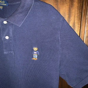 Marinblå Polo Ralph Laurent-shirt - Säljer en marinblå piké från Polo Ralph Lauren med den ikoniska broderade Polo Bear på bröstet. Vid minsta lilla fundering hör av er!!🔥Priset kan diskuteras vid snabb affär 