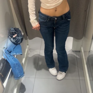 Mörkblå bootcut jeans med låg midja - Snygga mörkblå jeans med låg midja och bootcut passform. Jeansen har klassiska fem fickor och coola detaljer på bakfickorna med knapp. Perfekta för dig som gillar en avslappnad men ändå trendig! Pris kan diskuteras och skriv för fler bilder 💓