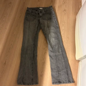Grå bootcut jeans från Gina Tricot - Snygga grå jeans från Gina Tricot i storlek 158. Modellen har bootcut-ben, klassiska fickor fram och bak samt markerade sömmar längs benen. Jeansen är i mjukt denimtyg och har en cool, lite tvättad look. Inte fri frakt! 
