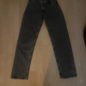 Svarta straight jeans mid waist W25 L30 - Säljer ett par svarta jeans med rak passform och midja i midwaist. Jeansen har klassisk femficksdesign och är tillverkade i denim. Perfekta för dig som gillar en clean och tidlös look.
