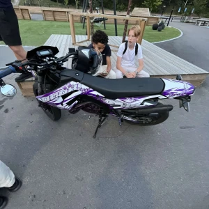 Motard TM 50 - Cool och sportig Motard TM 50 med lila och vita detaljer. Perfekt för dig som gillar fart, stil och att hänga med kompisarna. Snygg design som sticker ut på gatan och passar unga motorintresserade.